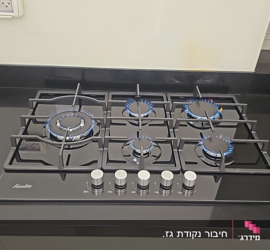 כיריים גז עם להבות כחולות במטבח מודרני